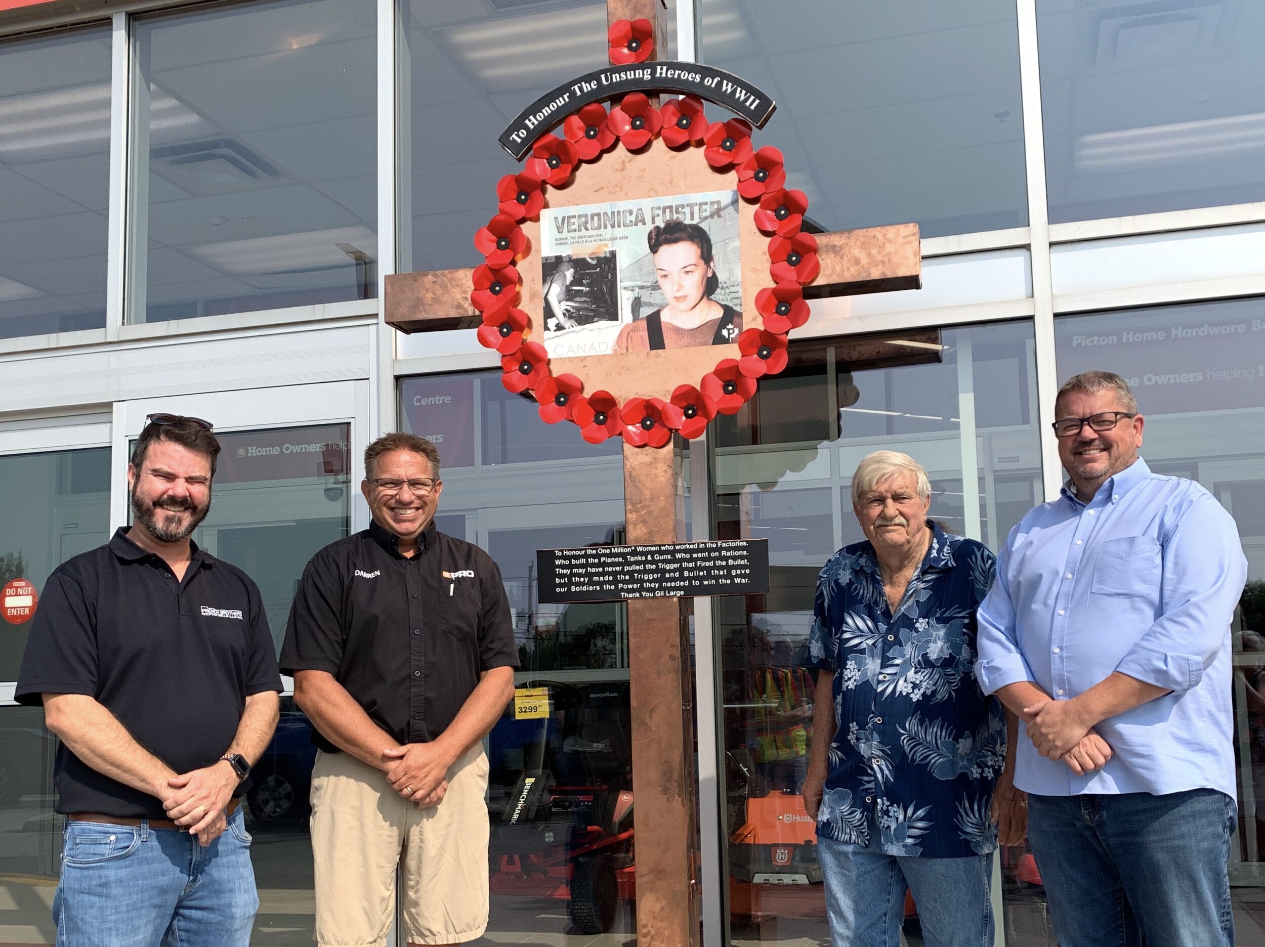 <p>(From Left) Adam Doran of French Brothers Roofing and Mark and Adam Busscher of Picton Home Hardware flank retired sheet metal worker and West Lake resident Gil Large. Supported by French Brothers and Picton Home Hardware, Mr. Large created a memorial copper cross and wreath to honour the women of Canada who assisted in the allied effort of World War II by working in factories and mills during the early 1940’s. (Jason Parks/Gazette Staff)</p>

