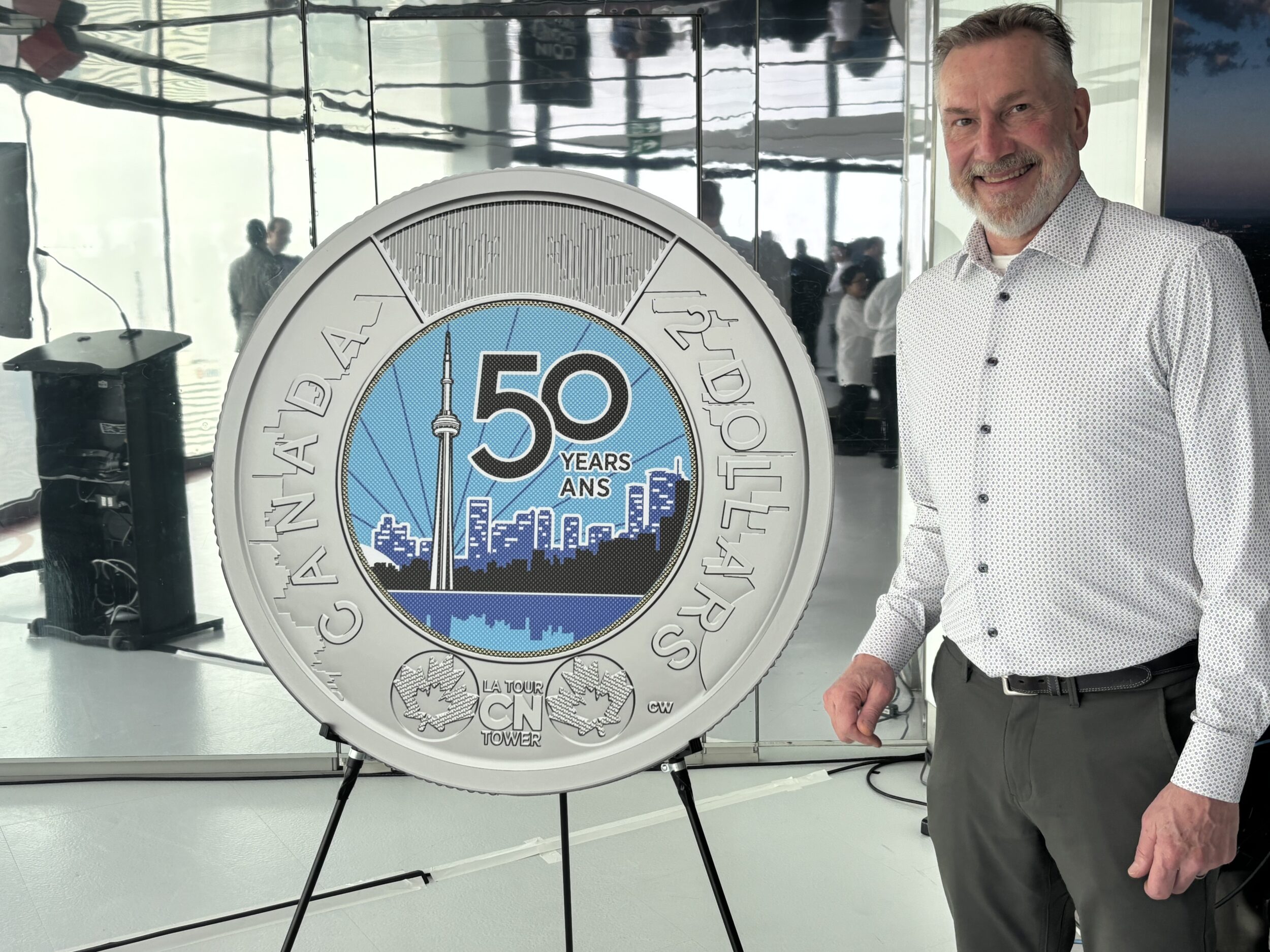 <p>Former Picton resident Carl Weins with Canada’s newest $2 coin. Mr. Weins designed the image inside the toonie, a tribute to the 50th anniversary of the official opening of the CN Tower. (Supplied Photo) </p>
