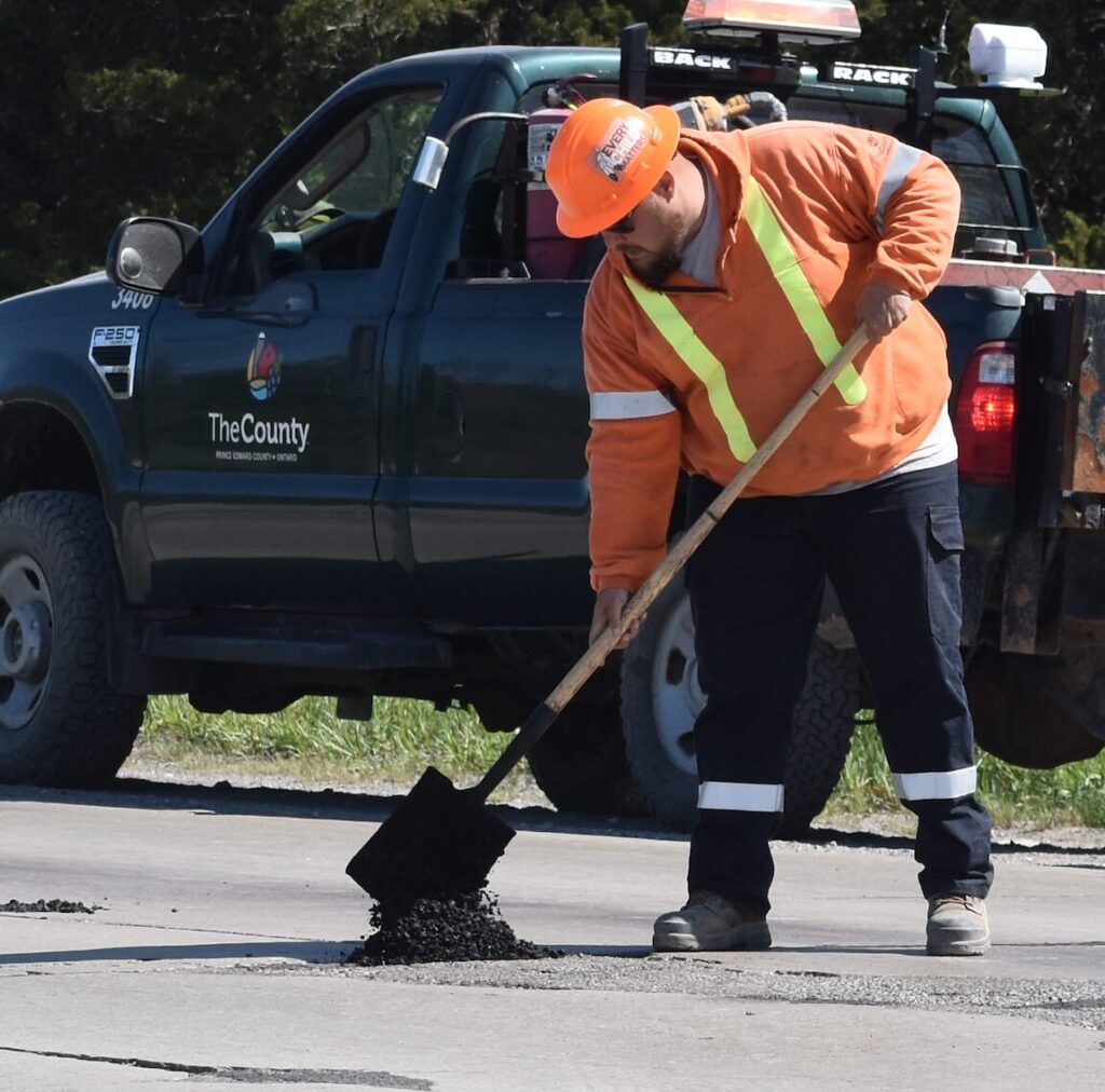 <p>A worker fills in a pothole along County Road 49 in this Gazette File Photo. (Jason Parks/Gazette Staff)</p>
