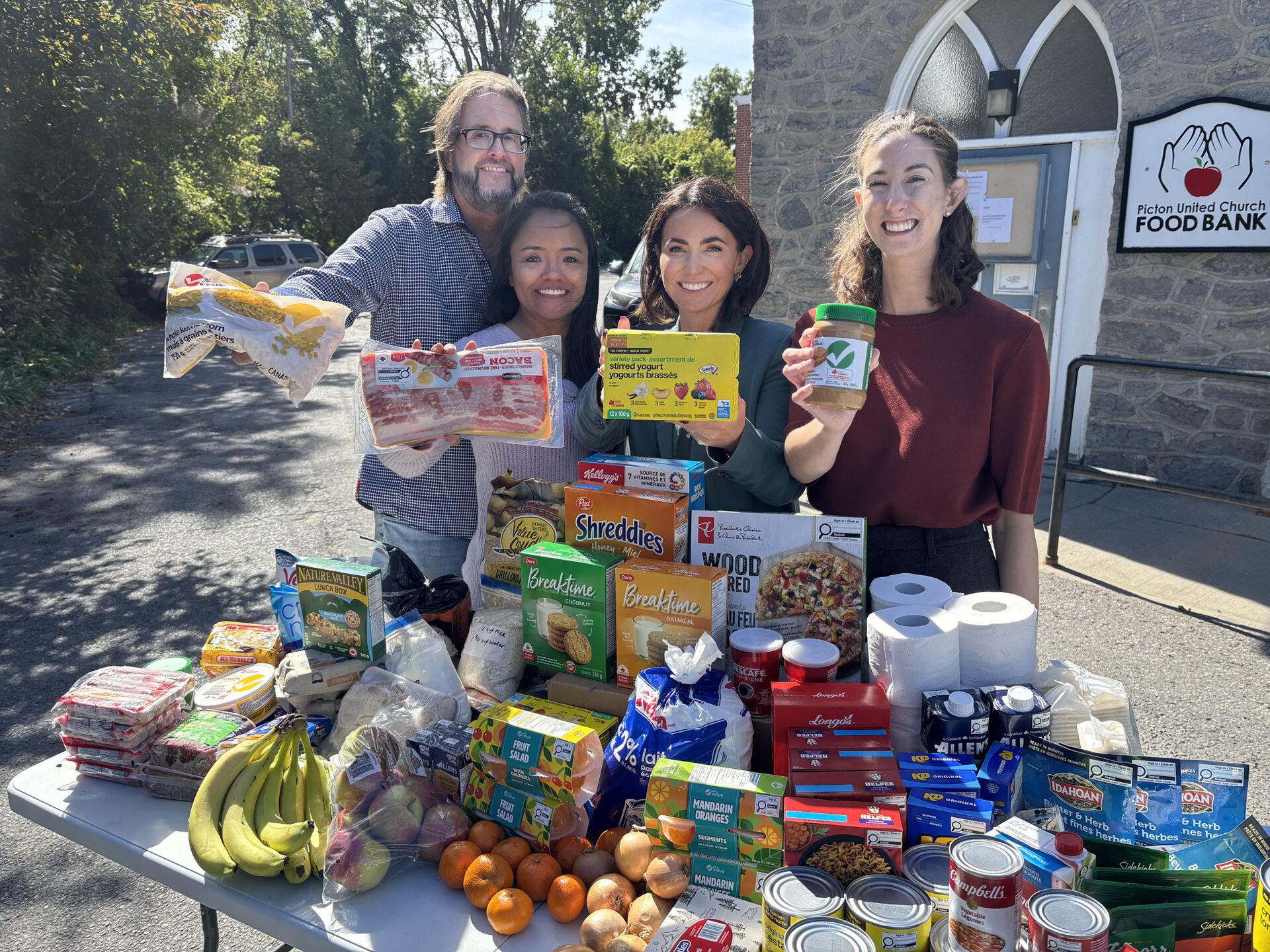 <p>Donors Mark and Erika Houghton join the County Foundation’s Dominique Jones and Gillian Armstrong outside the Picton United Church Food Bank. (Josh Thomas/Gazette Staff)</p>
